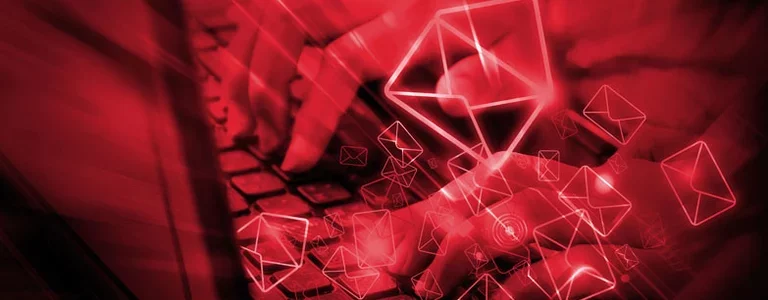 Hands typing with red email icons floating in the foreground