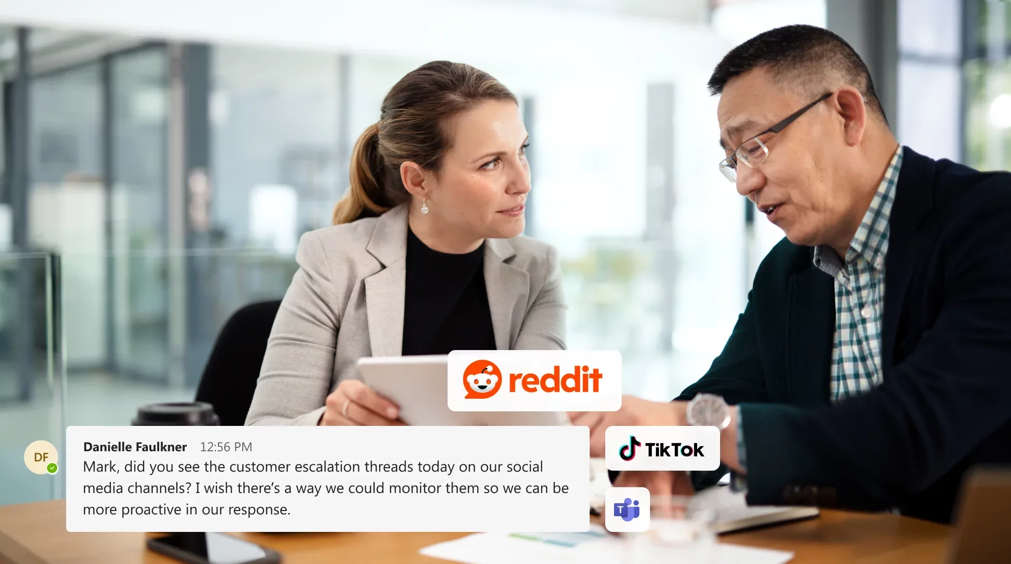 Two colleagues looking at a tablet with social media logos, discussing data governance security